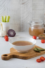 A plate with healthy homemade bone broth on a wooden board. The concept of healthy food.