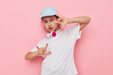 little girl headphones in a white t-shirt and a cap childhood unaltered