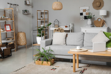 Interior of modern room with stylish sofa and laptop on table
