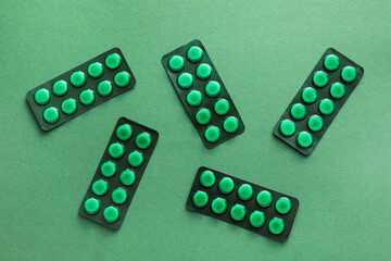 Blister packs with pills on green background