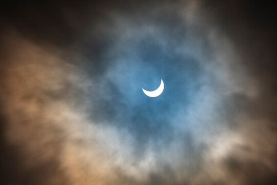 partial solar eclipse on cloudy day - Powered by Adobe