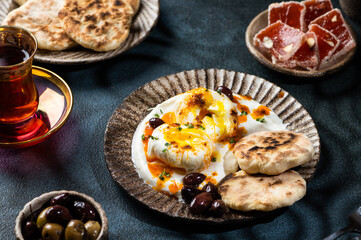 Cilbir or Turkish Eggs. mezze: poached eggs topped over herbed greek yogurt, then drizzled with hot spiced paprika olive oil. Traditional Turkish breakfast with rahat