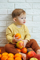 Smiling child eats one fresh juicy red apple. Healthy fruits for young children. The child eats fruits and vegetables.