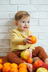 Smiling child eats one fresh juicy red apple. Healthy fruits for young children. The child eats fruits and vegetables.