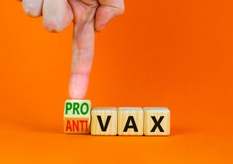 Pro-vax or anti-vax Covid-19 symbol. Doctor turns cubes, changes words Anti-vax to Pro-vax. Beautiful orange table orange background. Copy space. Business medical covid-19 pro-vax or anti-vax concept.