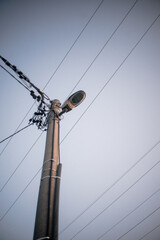 The street electric pole with a lamp and lot of wires - obrazy, fototapety, plakaty