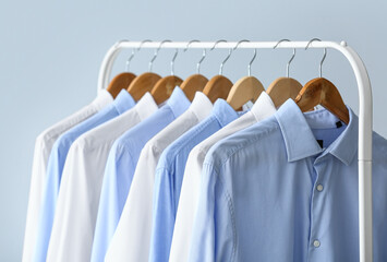 Rack with clean shirts on grey background