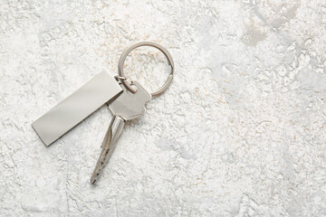 Key with stylish silver keychain on light background