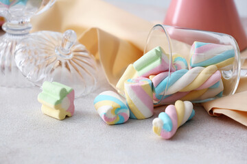Glass with tasty marshmallows on light background, closeup