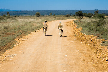 Two heavily armed park rangers patrolling the dirt roads in Nairobi National Park, Kenya, to...