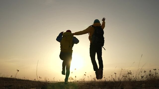 business teamwork a freedom concept. couple of tourists run silhouette with backpacks running jumping. travel freedom business sunset fun concept. couple teamwork hikers running jumping