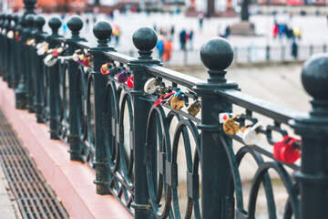 Heart-shaped padlock hanging on a bridge. White, gold and red love lock. Wedding tradition. Locks on the bridge in Yoshkar-Ola, Russia. Valentine's Day background.