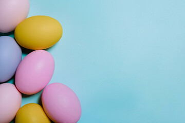 Happy Easter card with copy space for text. Colorful easter eggs isolated on pastel blue background with space. Seven colorful easter eggs. Top view with copy space. Easter background.