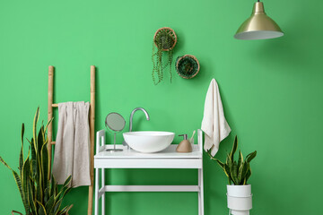 Interior of stylish bathroom with white table, sink and ladder