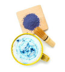 Cup of tasty blue matcha latte, chasen and powder on white background
