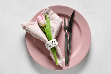 Stylish table setting with tulip flower on light background