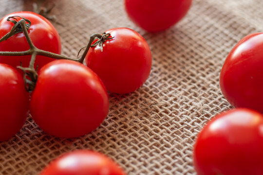 several small tomatoes on a straw table
