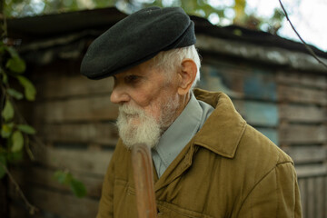 Portrait of an old man. A man with a gray beard. An old man over ninety years old. Gray grandfather in a black cap. The face of a deep old man.