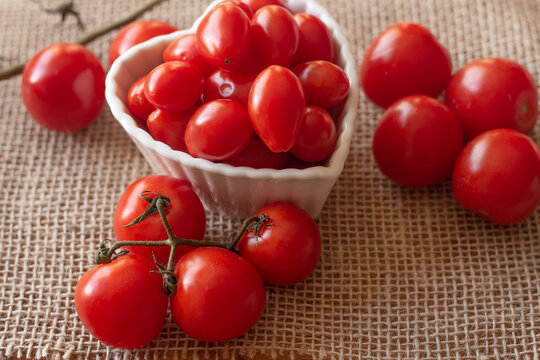 tomatoes inside a white bowl and on to a straw table