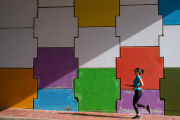 Woman running in front of a multicolored background