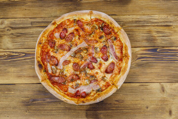 Delicious fresh pizza with sausage, mushrooms and cheese on a wooden table. Top view