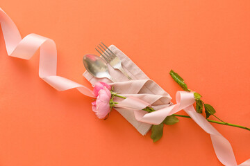 Stylish cutlery with flowers on coral background