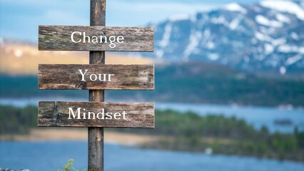 change your mindset text on wooden signpost outdoors in landscape scenery during blue hour and sunset.