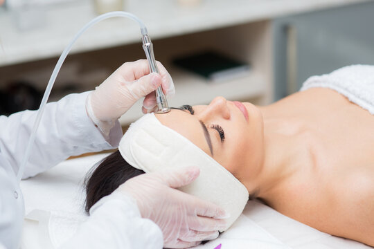 portrait of a woman receiving diamond microdermabrasion treatment. skin care, beauty salon, close up