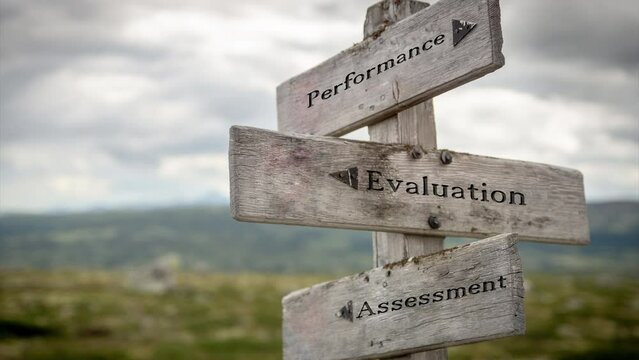 performance evaluation text quote on wooden signpost outdoors in nature. Slow pan and zoom 4k video footage.