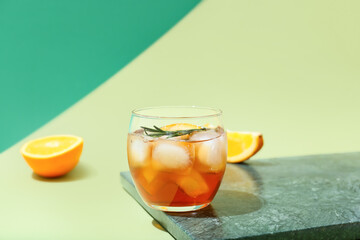 Glass of delicious Old Fashioned Cocktail on color background