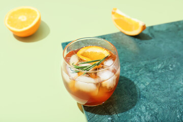 Glass of delicious Old Fashioned Cocktail on green background