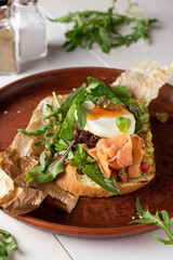 Bruschetta with avocado, salted salmon, microgreens and poached egg, Closeup
