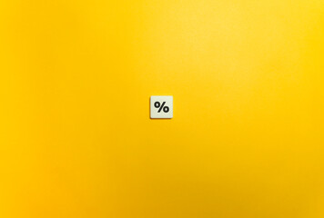 Percentage symbol on letter tile on yellow background. 