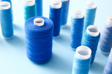 Thread spools on blue background, closeup