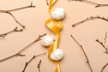 Composition with beautiful Easter eggs, tree branches and ribbon on color background