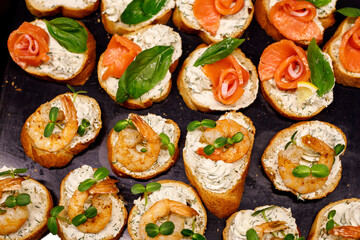 Top view of various Bruschettas with salmon and shrimps. Seafood sandwiches.