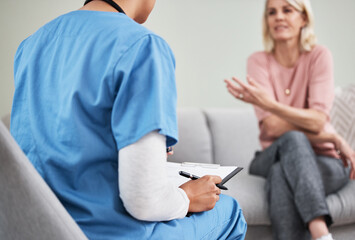 A good listener makes a good doctor. Shot of a female nurse sitting with a clipboard while having a...