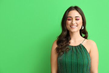 Smiling woman with creative makeup on green background. International Women's Day