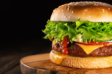 Tasty burger with smoke, fast food concept. Fresh homemade grilled hamburger with meat patty, copy...