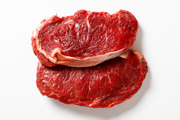raw striploin beef steaks on a white