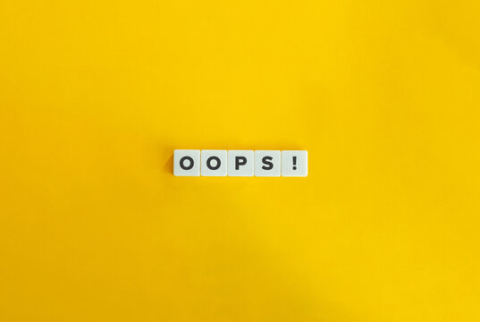 Oops word on letter tiles on bright orange background. Minimal aesthetics.