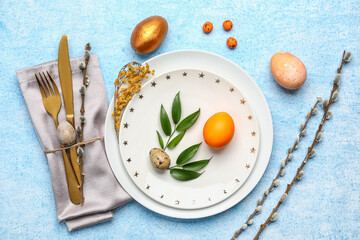 Stylish Easter table setting on blue background