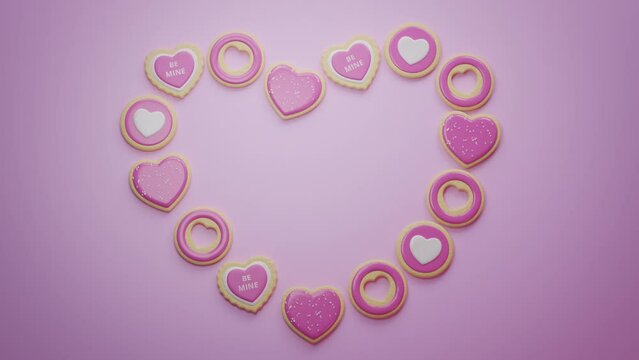 Stop motion heart shape making with Valentine’s Day festive pink colored sugar cookies. Cute pink background. Realistic sweet candies. Handmade valentines Celebrative greetings. 3D Render 4K animation