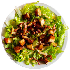 Lettuce, crouton, lardon French salad served on plate. Isolated over white background
