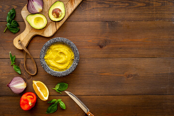 Mexican spicy guacamole avocado dip in mortar with ingredients