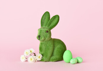 Cute Easter bunny with eggs and flowers on pink background