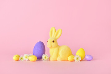 Cute Easter bunny with eggs and flowers on pink background