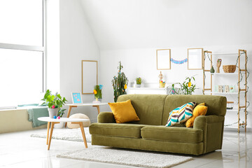 Interior of light living room with green sofa and Easter eggs