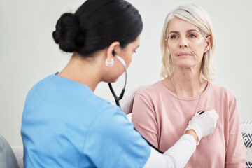 Let me take a listen. Shot of a female doctor examining a patient with a stethoscope.