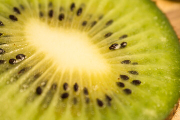 Fresh green kiwi cut into rings on a wooden background close-up.